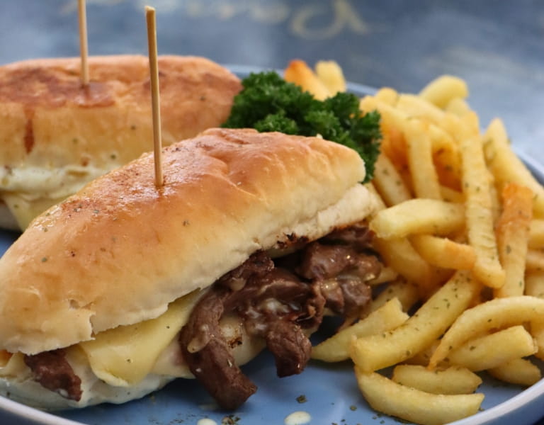 Sándwich de lomo con queso derretido y papas fritas